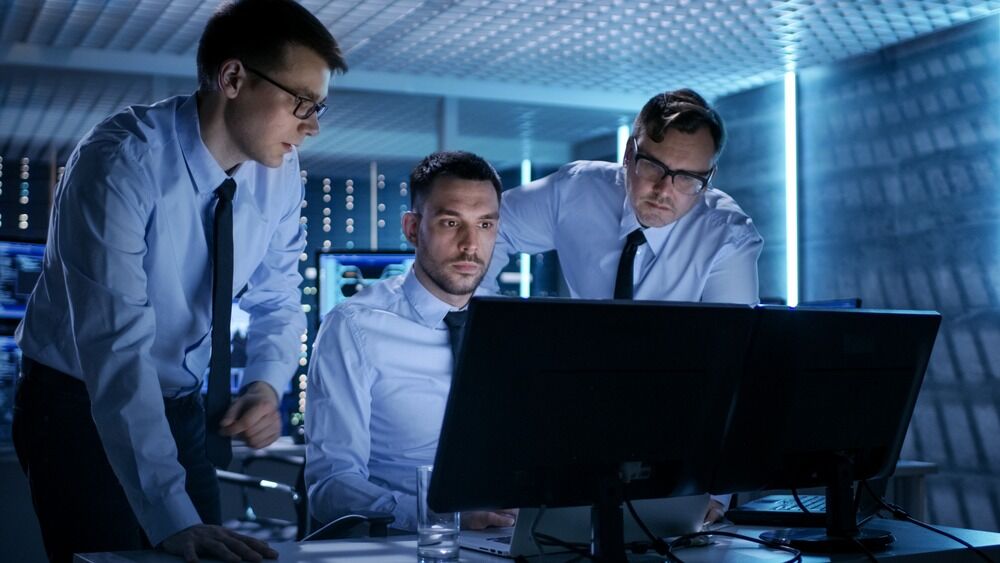 Group of men discussing IT support while conducting monitoring services