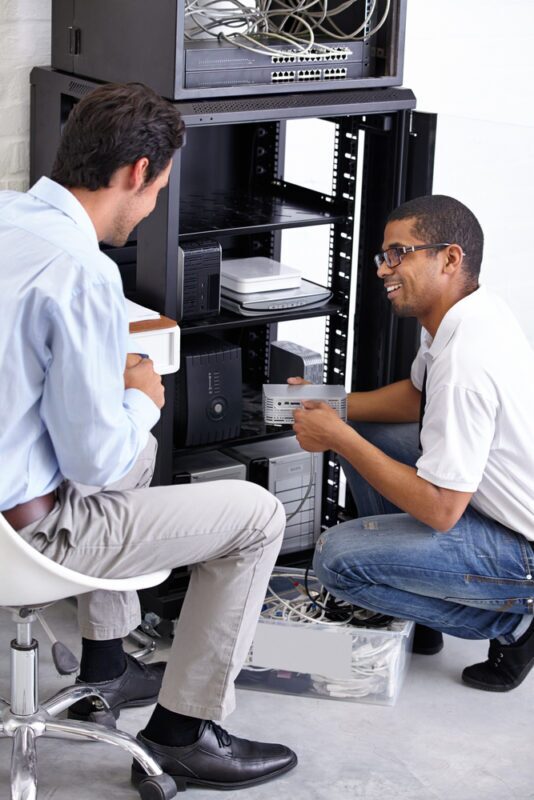 IT technicians in Singapore assessing network infrastructure for Wi-Fi assessment services in Singapore, ensuring optimal performance