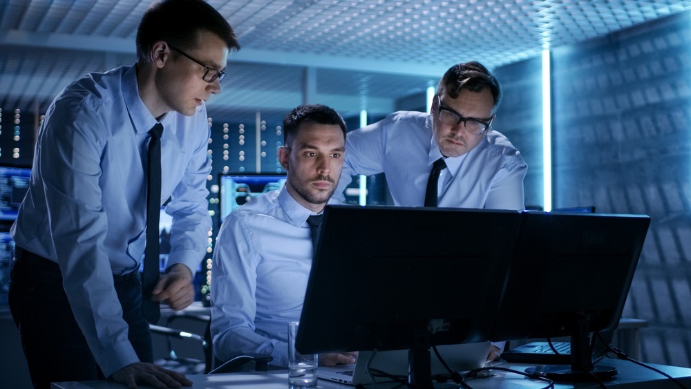 Men discussing IT issues to provide computer support for internal users Group of men discussing IT support while conducting monitoring services