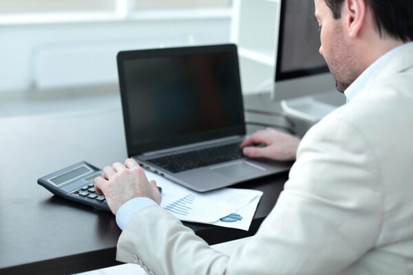 6 Critical Factors to Consider When Outsourcing IT Support Services 4 Businessman analyzing business expenses, focusing on evaluation of IT support outsourcing companies