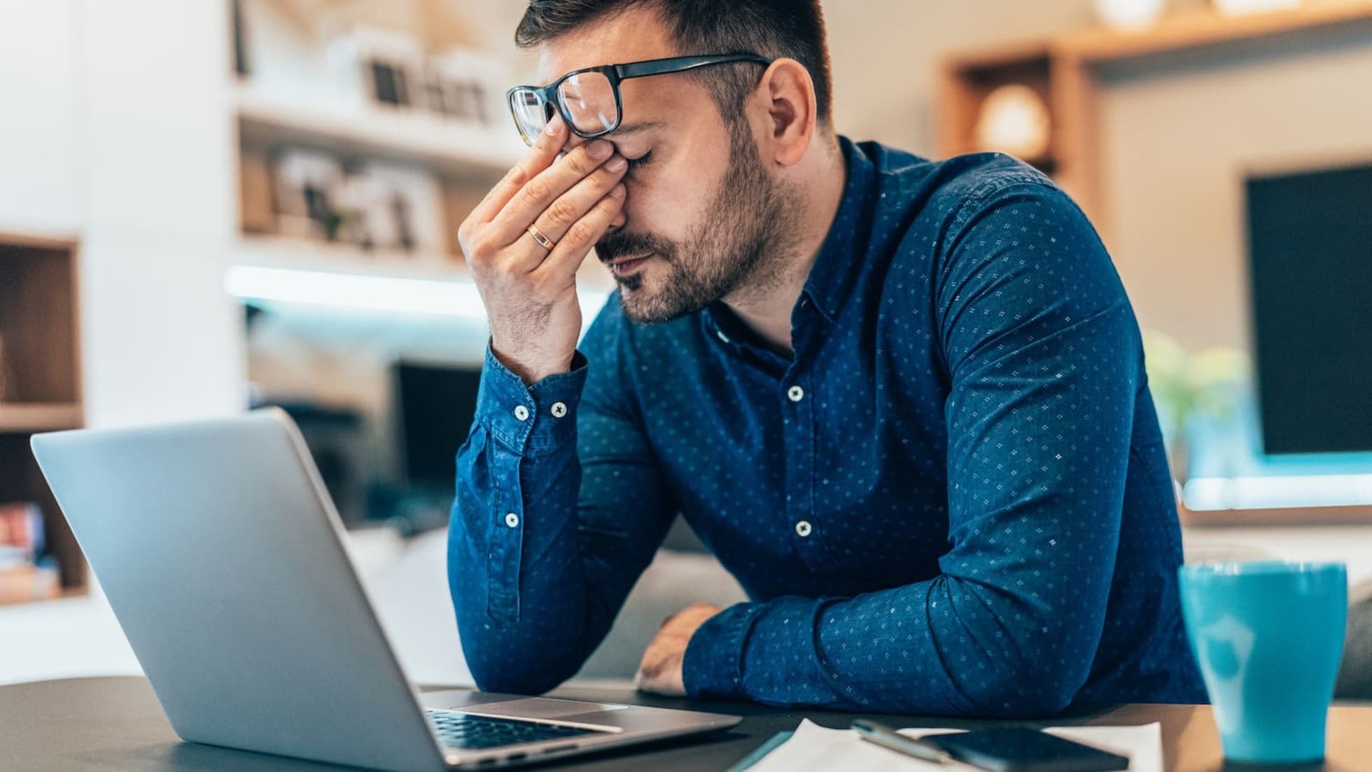 How Many WiFi Devices Is Too Many? 3 Frustrated young man in front of his laptop. Work gets disrupted due to connectivity issues caused by Wi-Fi.