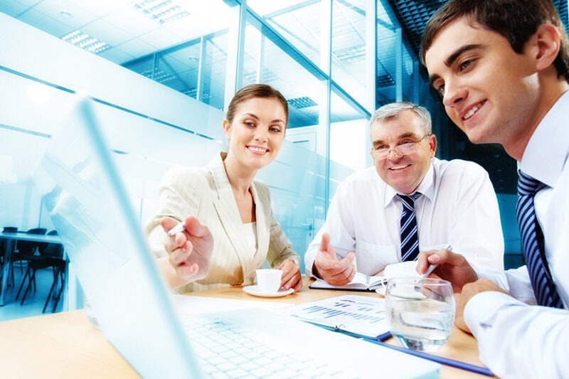 Leveraging IT Consulting to Fortify Financial Services Institutions 2 Group of professionals engaged in a discussion during a financial services IT consulting meeting in the office.