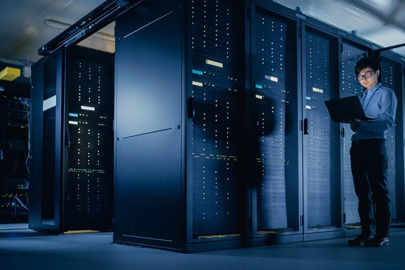 Navigating the Digital Minefield: Understanding and Implementing IT Security Assessment 2 IT specialist performing an IT security assessment using a laptop inside the server room