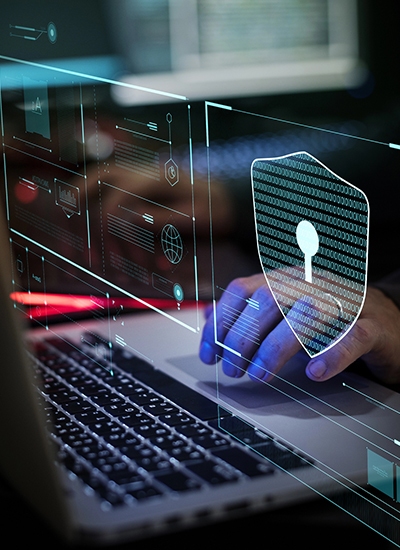 A futuristic, semi-transparent holographic interface floats showing a security icon, representing broad security assessment services.