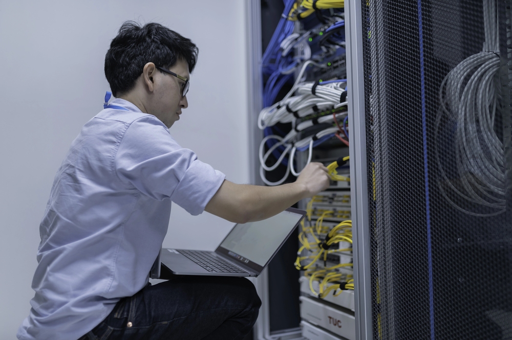 Computer engineer is setting up network in server room.