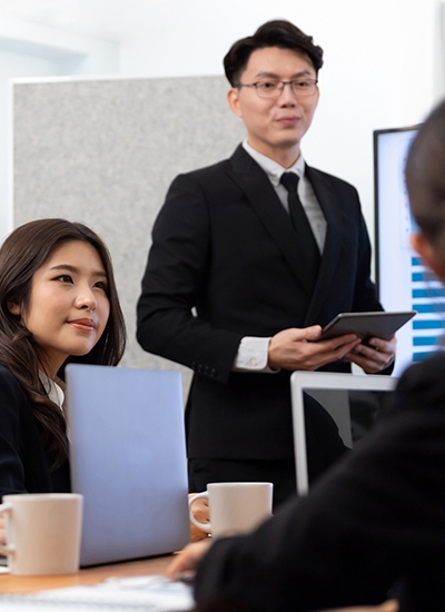 A team of IT professionals in a modern Japan-based office discussing IT infrastructure solutions and cybersecurity strategies, representing IT support services in Japan