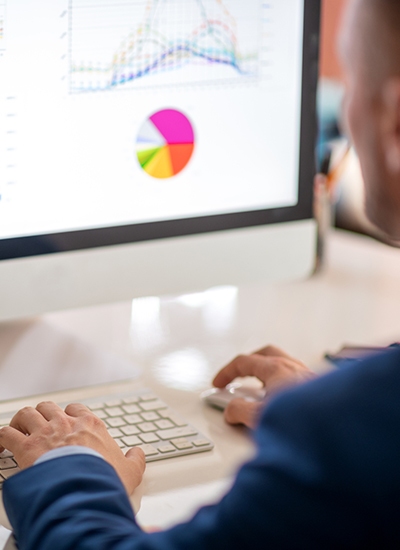 Business professional analyzing graphs on a computer, representing concierge IT services in Japan for data-driven solutions