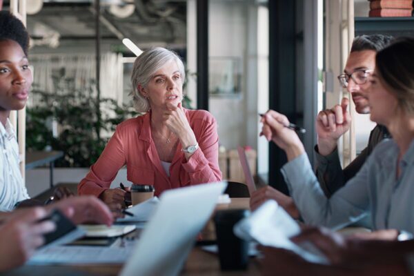 A group of professionals in a meeting room discussing developing a cloud integration strategy, showcasing teamwork and planning