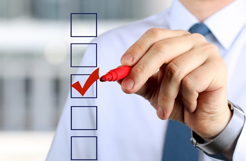 Businessman checking off a task on WiFi evaluation checklist for network improvement