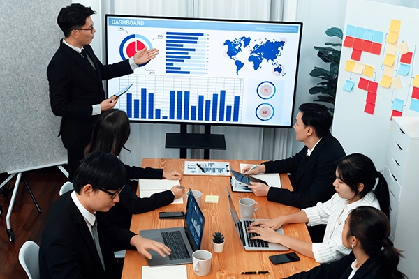 Project manager in Tokyo presenting to a team in a modern Japanese office. Project manager in Singapore presenting to a team in a modern office.