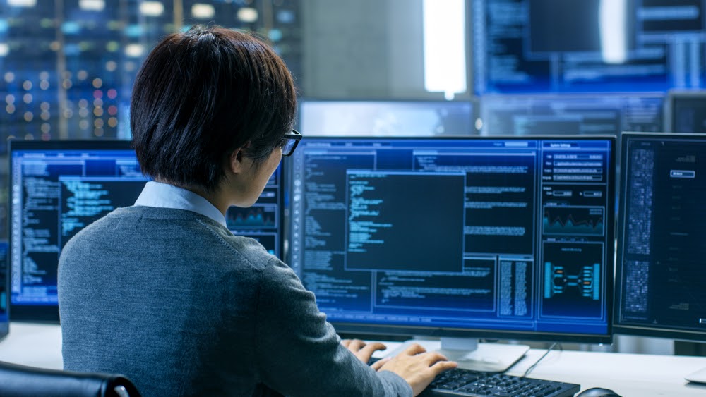 IT worker in system control room typing 