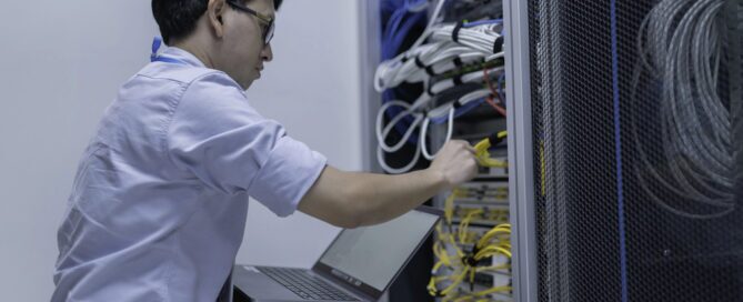 Computer engineer is setting up network in server room.